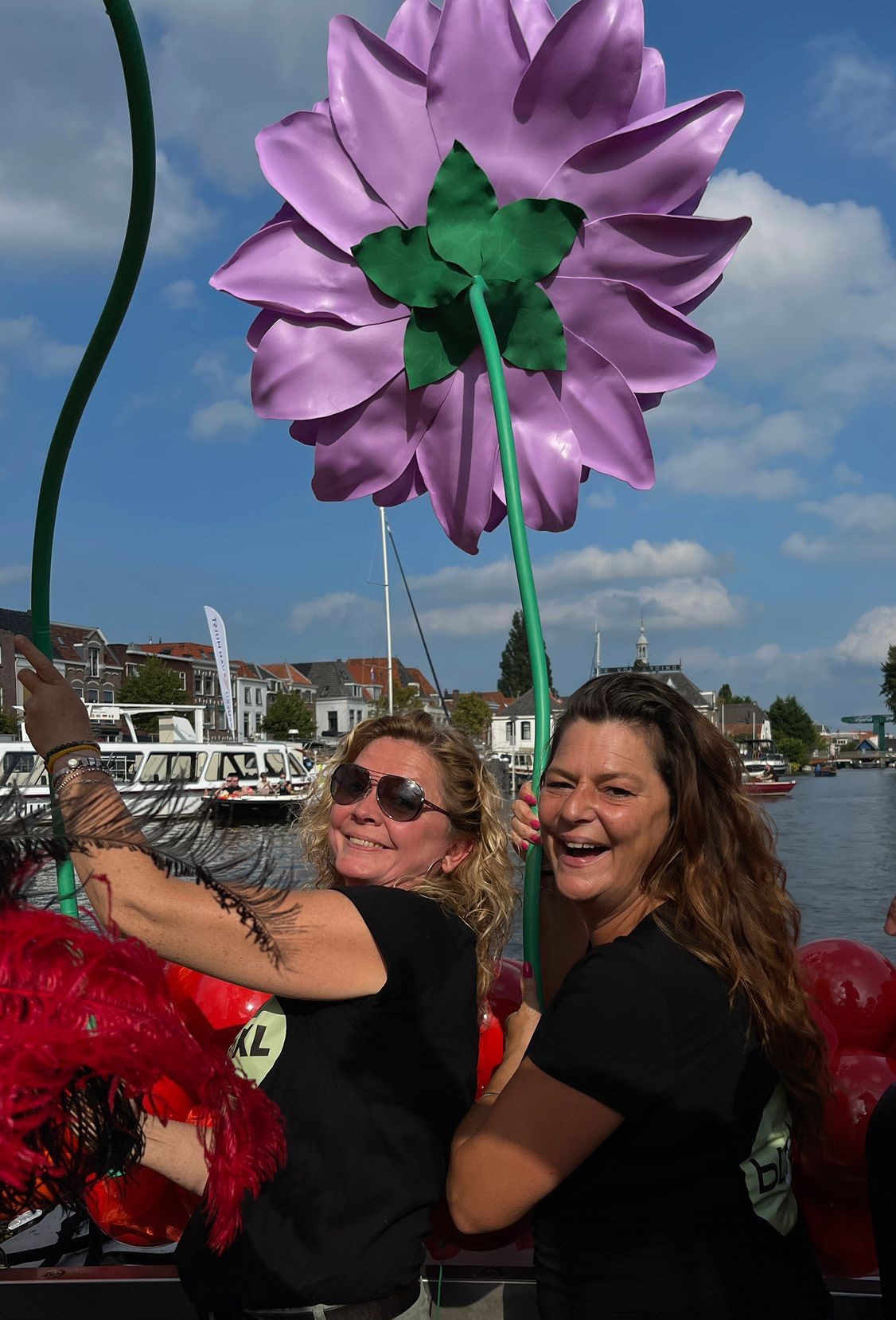 Marieke en Peet tijdens de pride Leiden op de boot. Samen met een popart XL bloem